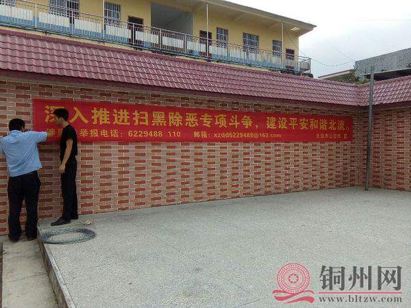 六靖派出所干警在龙湾小学围墙悬挂扫黑除恶相关标语.jpg
