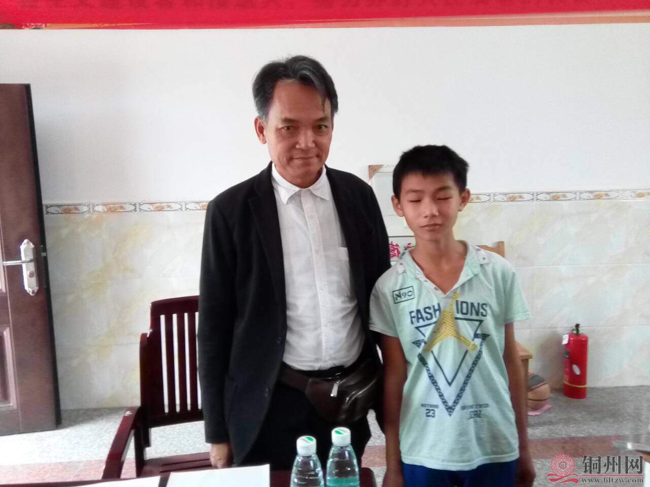 谢会长与龙湾小学的一名贫困学子合影.jpg
